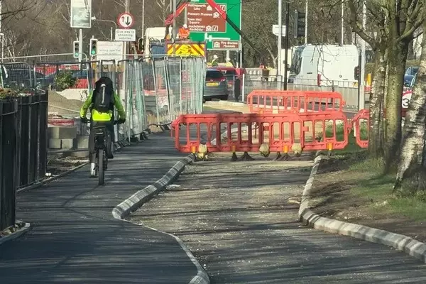 Cyclist's Sidewalk Ride Sparks Debate Amidst Unfinished Bike Lane Construction